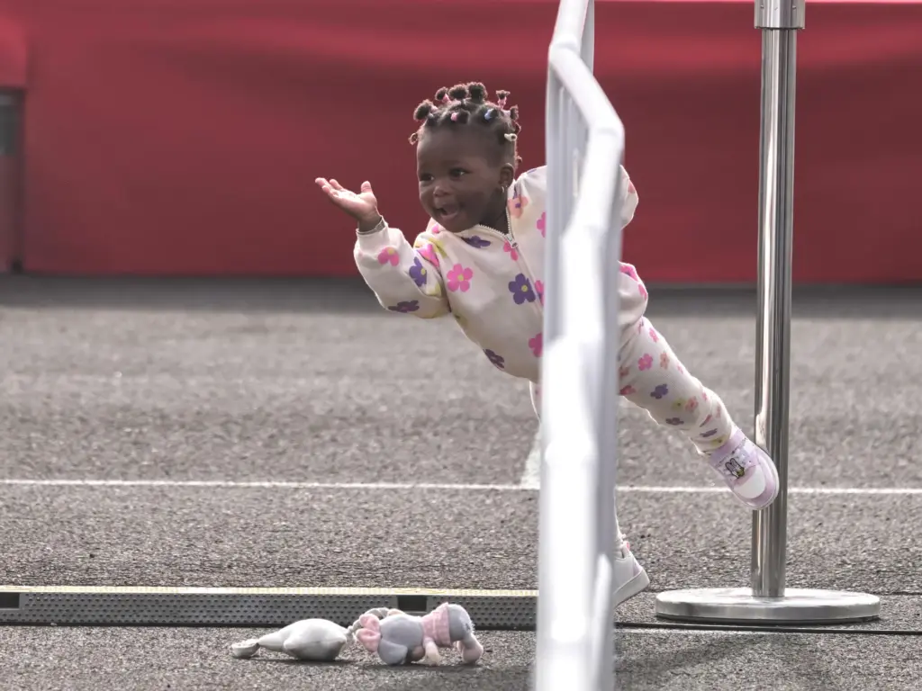 A girl plays as Pope Leo XIV arrives for a meeting with migrants.