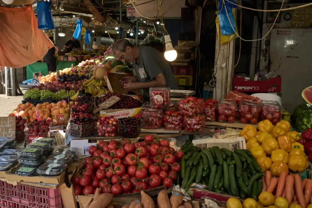 A vendor checks the fruits on his stand at a local street market in Haifa.
