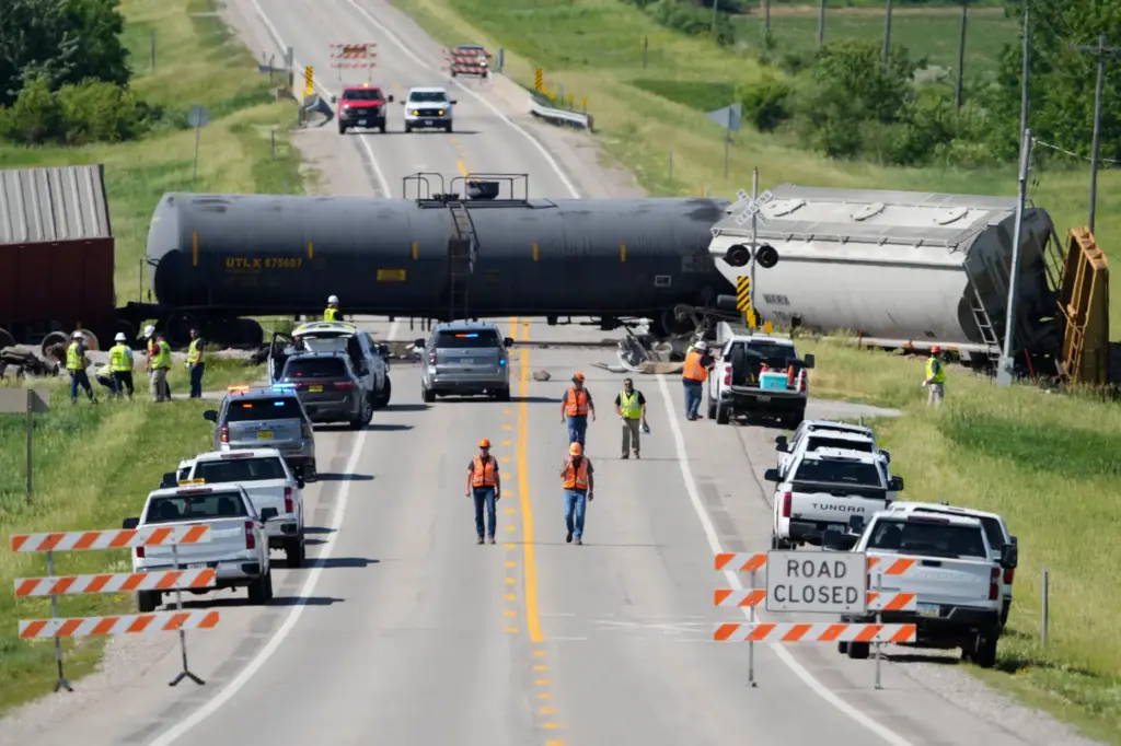 Workers respond after a train derailed on Wednesday, June 3,...