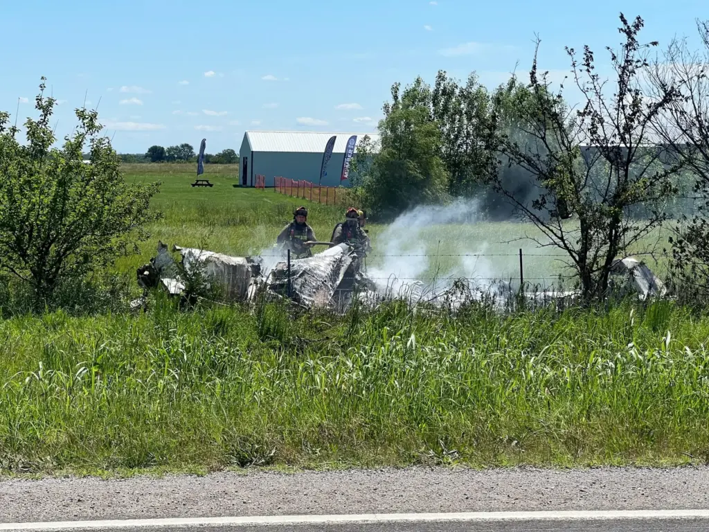 The wreckage of a plane crash burns in a field in Butler, Missouri.