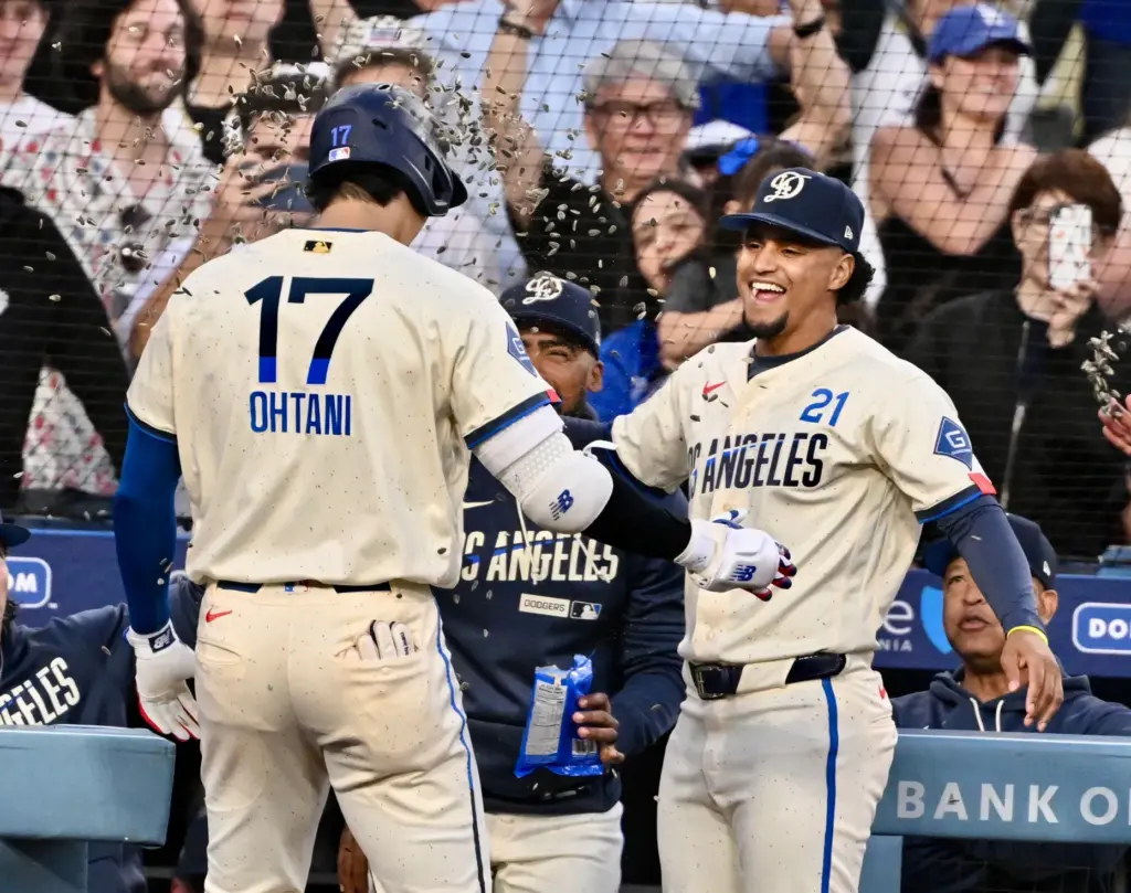Shohei Ohtani #17 of the Dodgers high fives teammate Santiago...