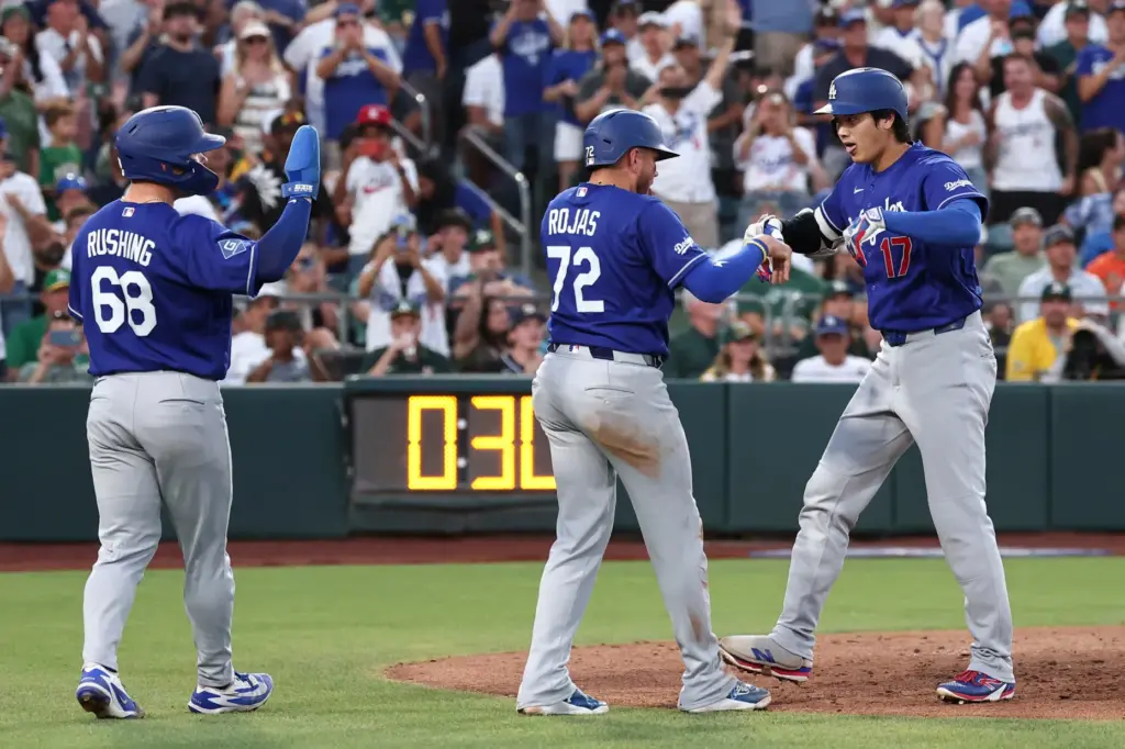 Dodgers star Shohei Ohtani, right, celebrates with teammate Miguel Rojas,...