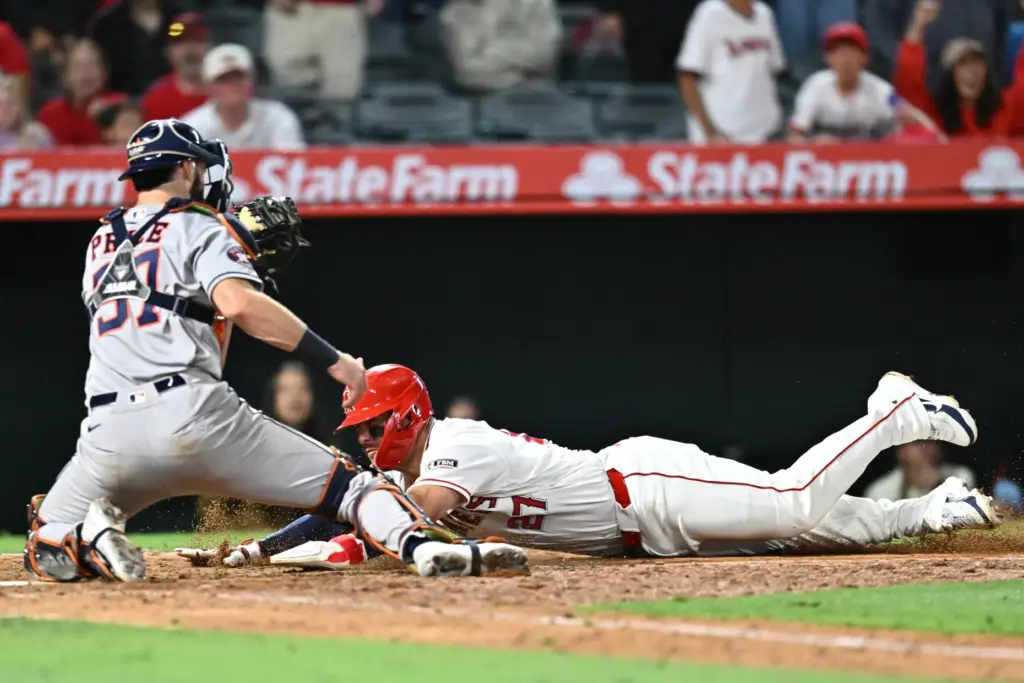 Angels star Mike Trout slides for the plate as the...