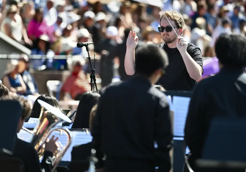Huntington Beach High Band Director Austin Floyd conducts his students...