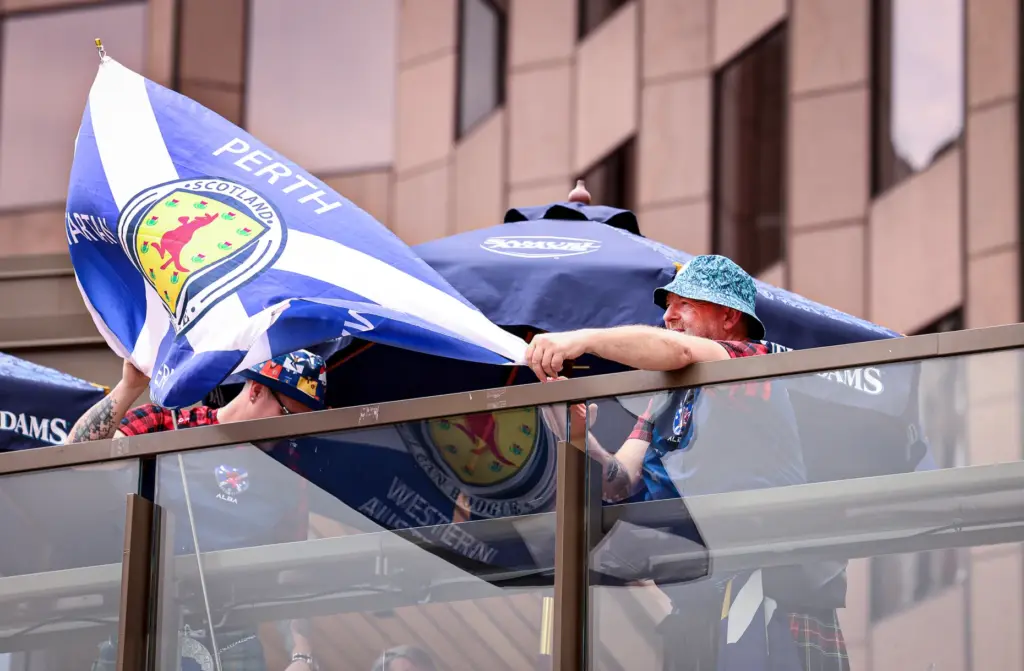 A member of the Tartan Army waves a flag from...