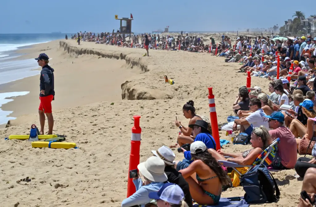 Beachgoers watch as bodyboarders take on big waves at The...