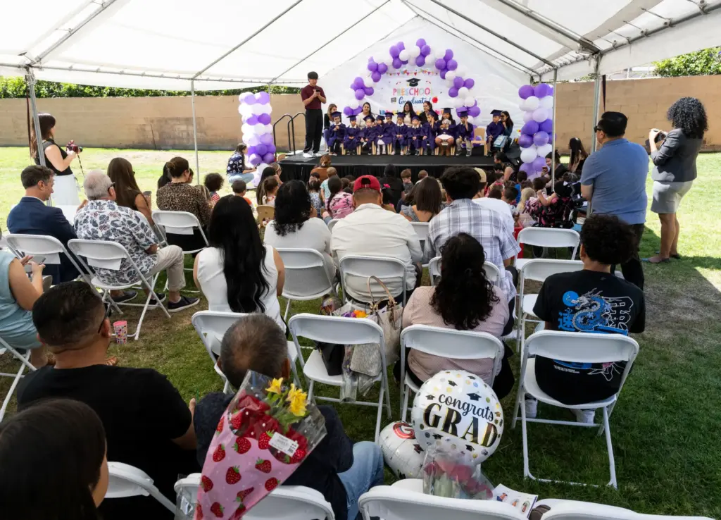 Students listen to speakers during their preschool promotion ceremony at...