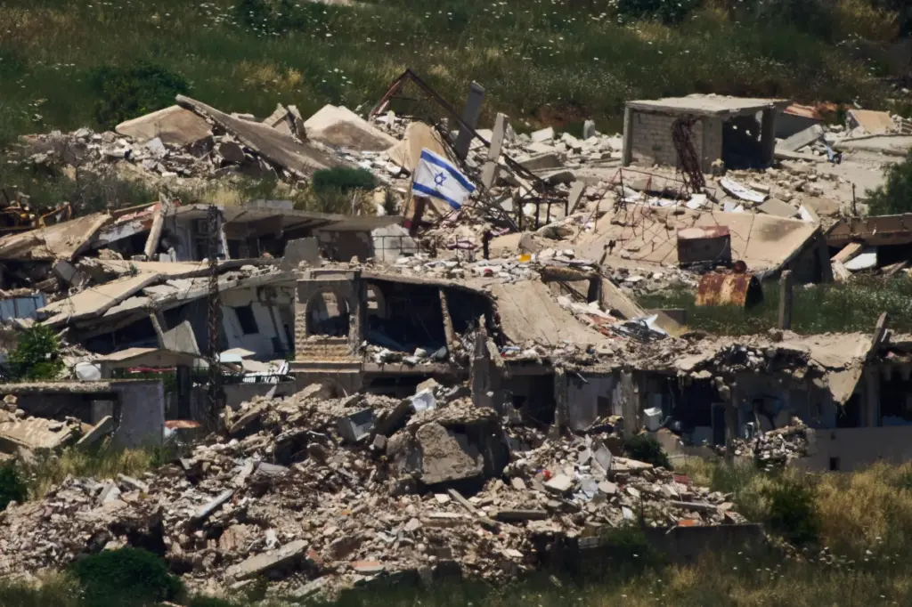 An Israeli flag hangs on a destroyed building in southern...
