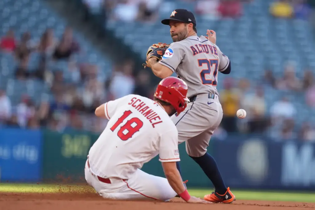 Houston Astros second baseman Jose Altuve, top, drops the ball...