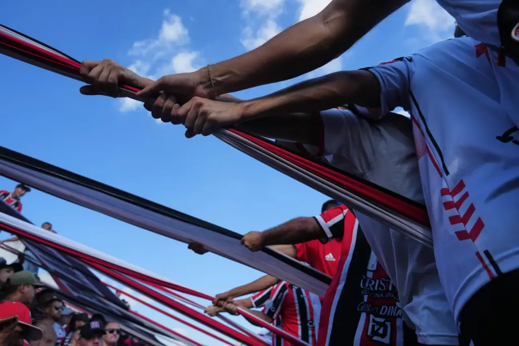 Chacarita Juniors fans hoist a flag from the stands.