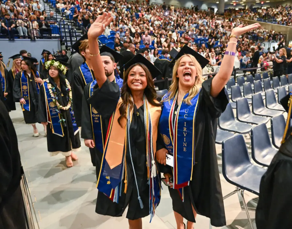 Graduates Amanda Zidron, left, and Vanessa Hicks wave to the...