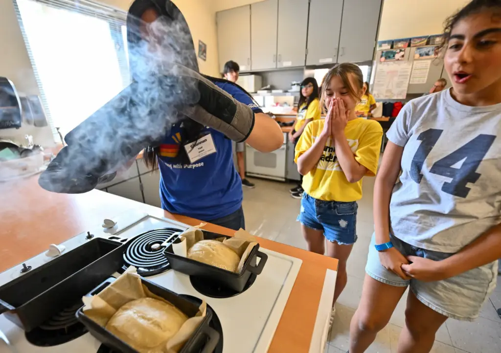 Campers Brooklyn Takeno, center, and Nahal Saatian, right, react as...