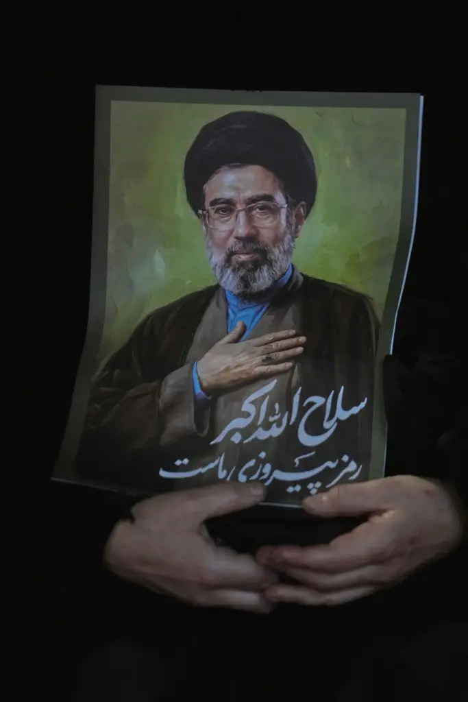 A woman holds a poster of the Iranian Supreme Leader Ayatollah Mojtaba Khamenei.