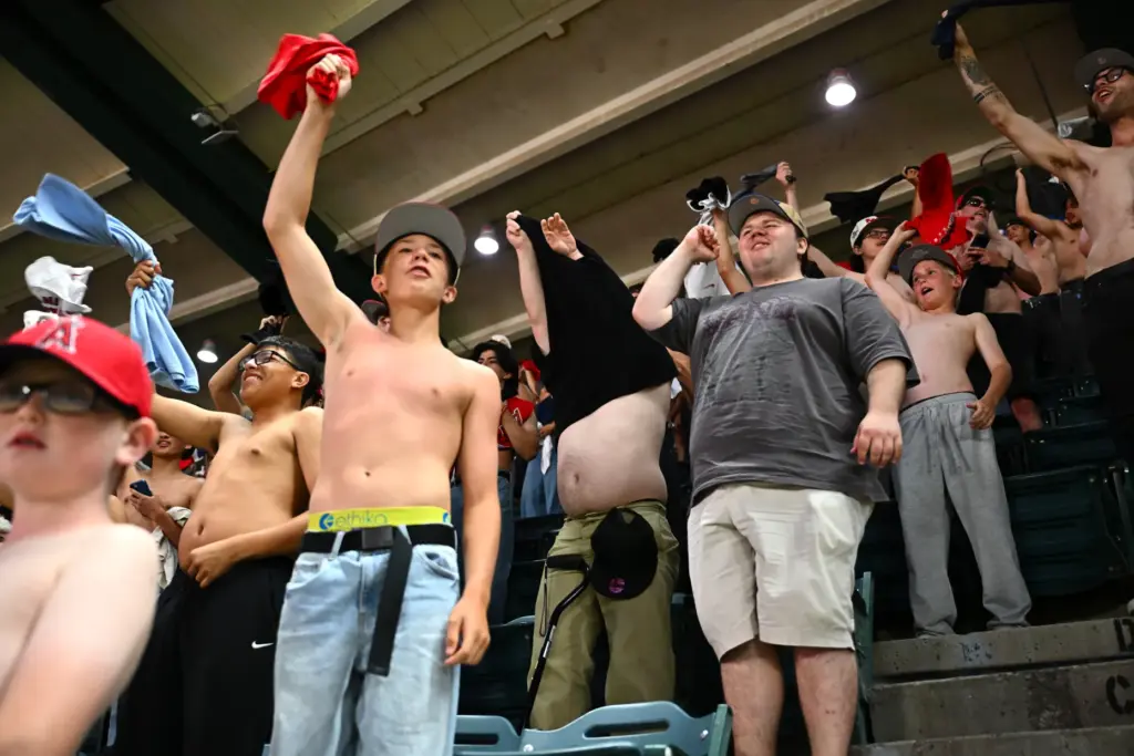 Mostly shirtless fans cheer during the sixth inning of a...