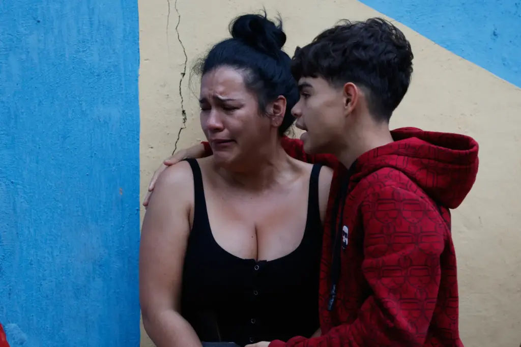 A boy comforts his mother after an earthquake in Caracas,...