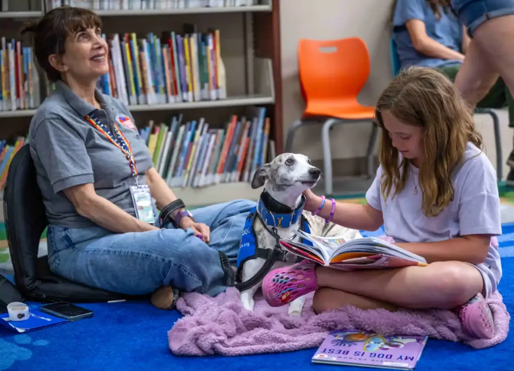 Olivia, 10, of Ladera Ranch, a third grader, pets Alfie,...