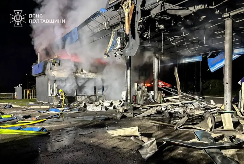 A rescue worker puts out a fire at a petrol station damaged by a Russian strike.