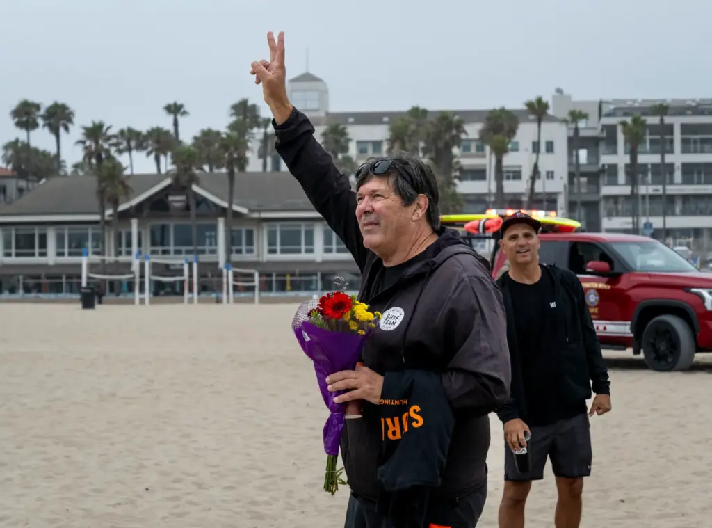 Huntington Beach High School surfing coach Andy Verdone acknowledges a...