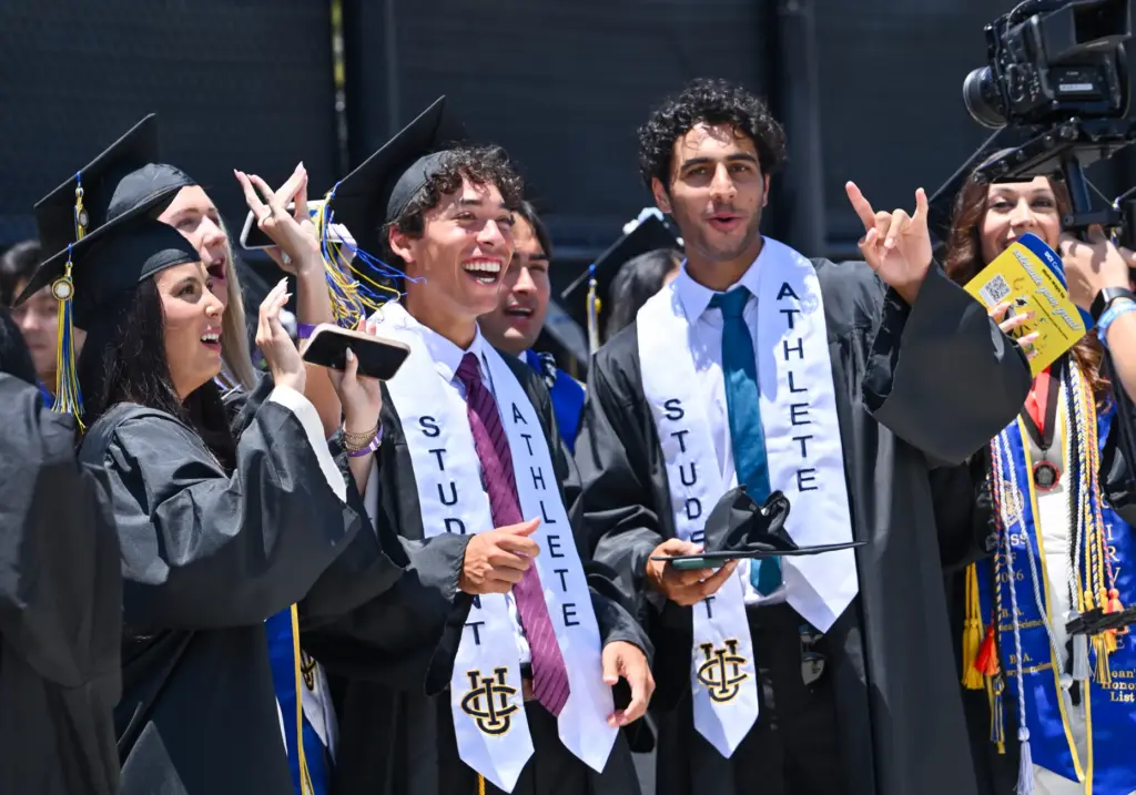 Graduates Mikaela Hinton, left, Max Fardanesh and Lawee Sherif cheer...