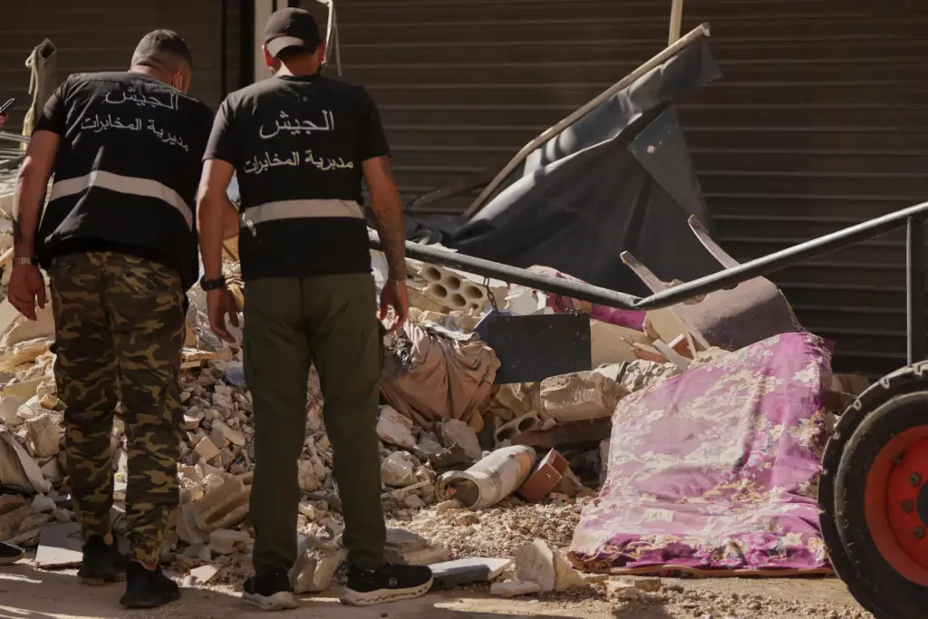 Lebanese intelligence officers look at an unexploded missile, centre, at...