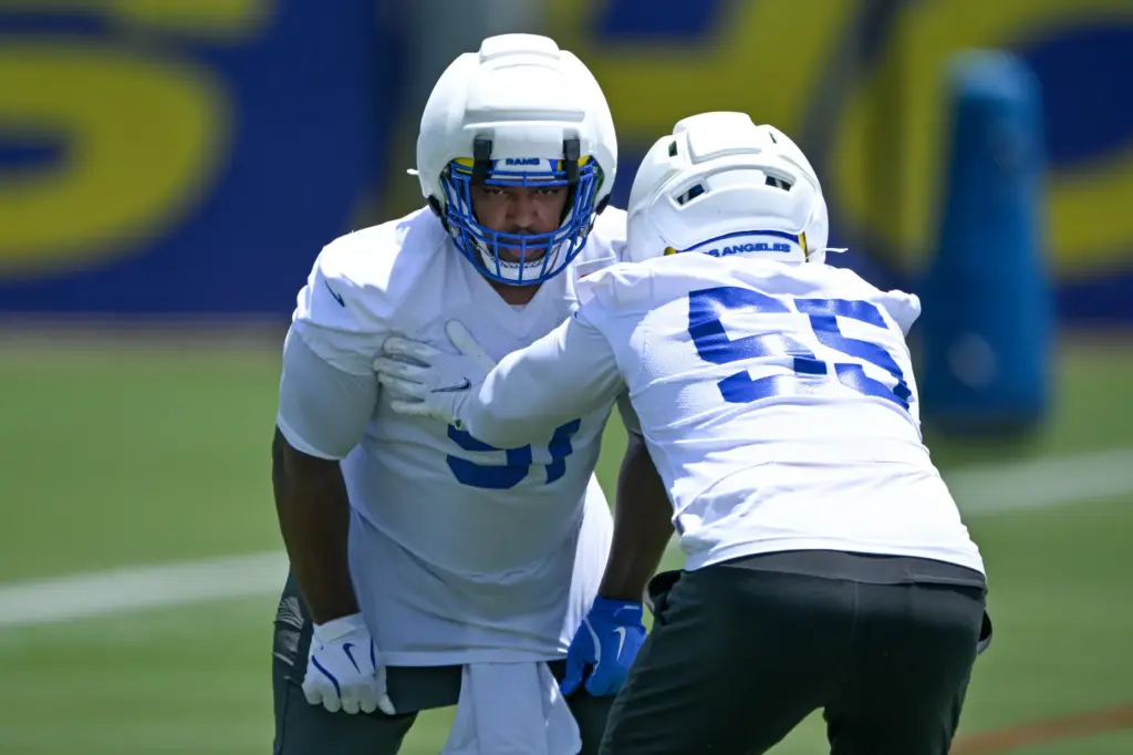 Rams defensive linemen Kobie Turner, left, and Braden Fiske go...