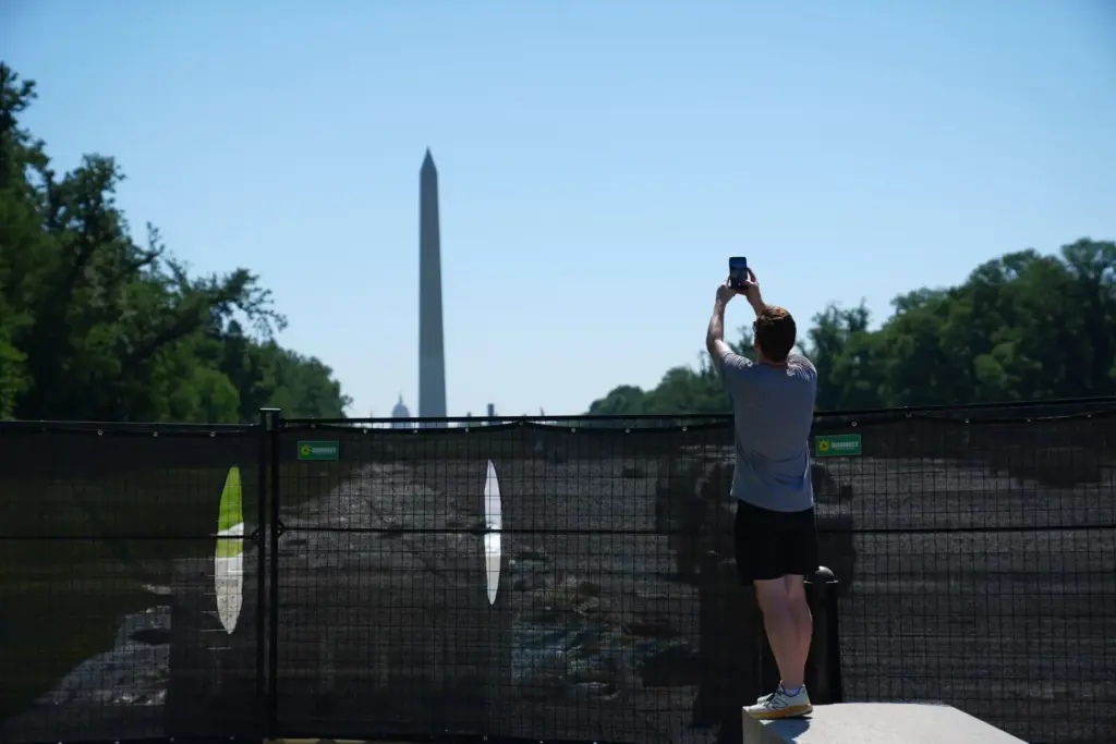 The Washington Monument is seen as an unidentified man takes...