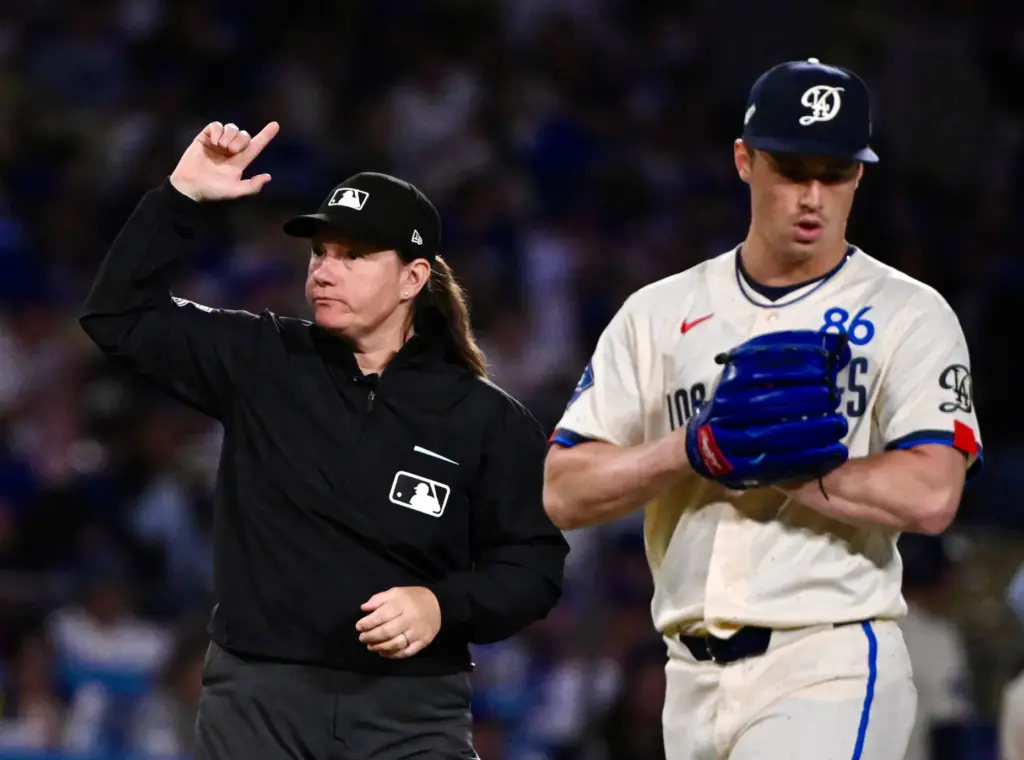 Third base umpire Jen Pawol after checking the glove of...