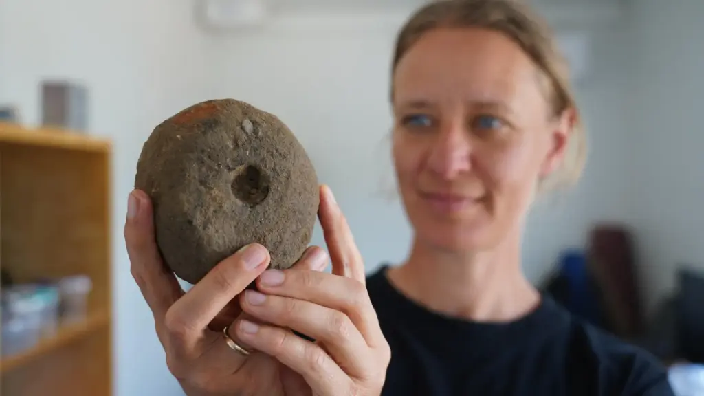 Moesgaard Museum archaeologist Liv Stidsing Reher-Langberg holds a Viking Age weight loom.