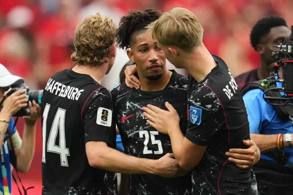 Canada’s Nathan Saliba, center, becomes emotional and is consoled by...
