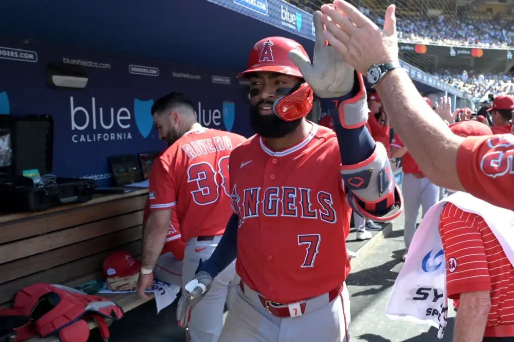 Angels’ Jo Adell is greeted in the dugout after hitting...