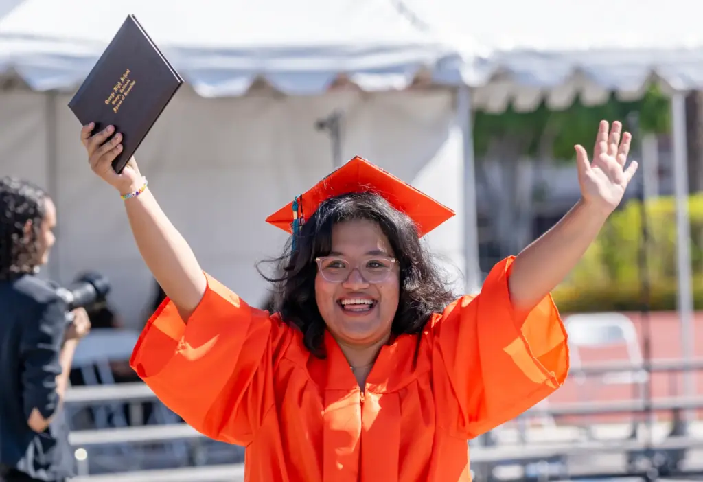 Abigail Godinez celebrates with her new diploma after walking across...