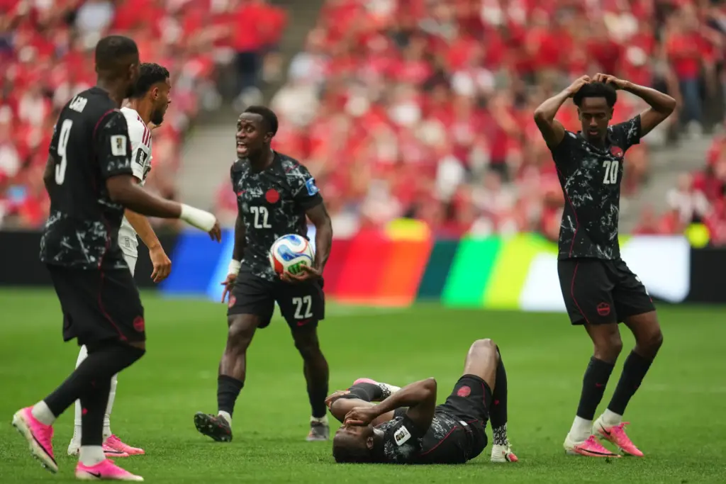 Canada’s Ismael Kone, below, lays on the ground after sustaining...
