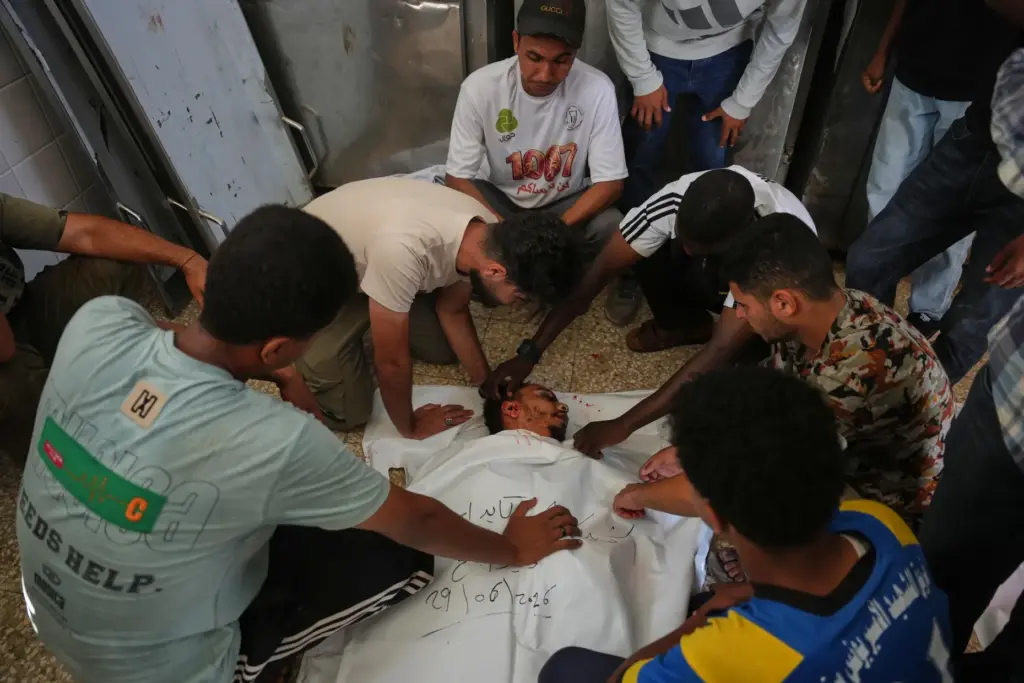 Palestinians mourn over the body of Ali Asbitan, 28, who...