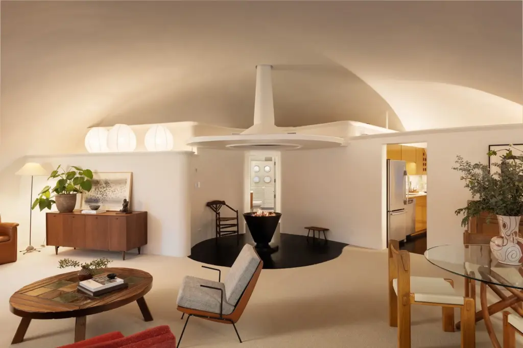 The fireplace anchors the half-circle living room in lauded architect...