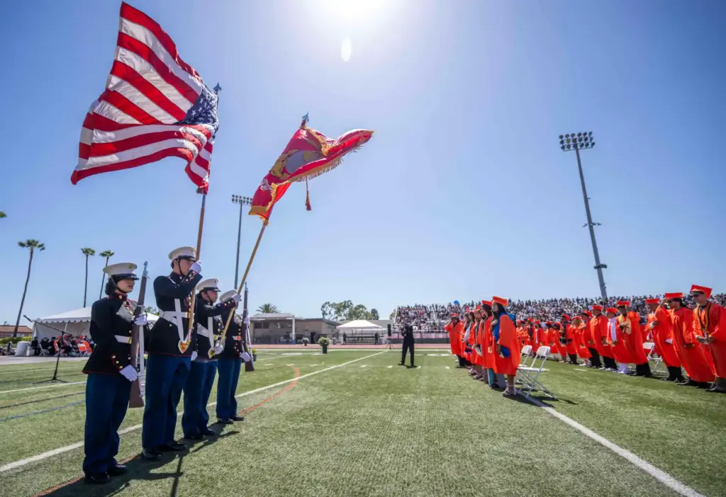 A Marine Corps Jr. R.O.T.C. Color Guard presents the flag...