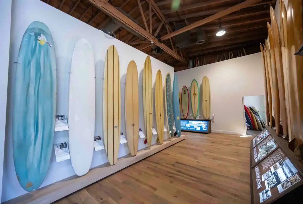 A collection of longboards, shaped by iconic surfboard creators, hang...