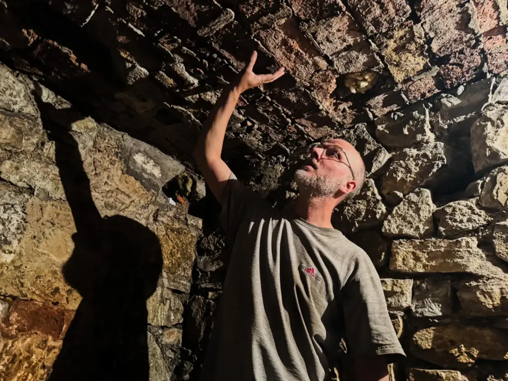 Piotr Jakowenko shows the entrance to the underground hideout of Jewish residents.