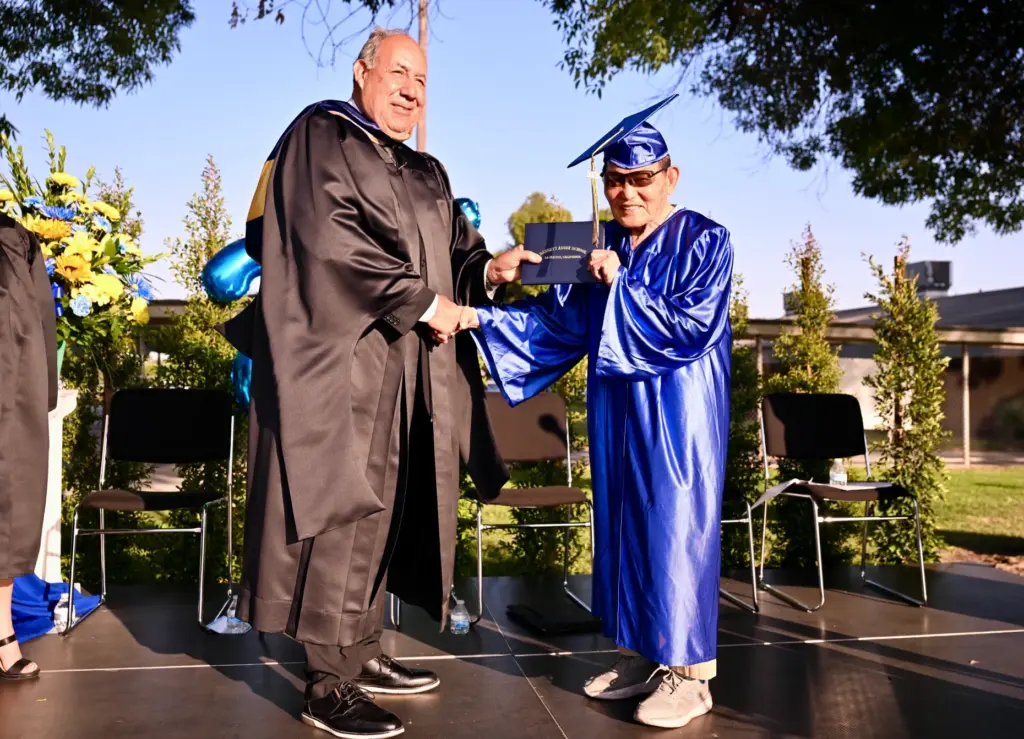 Soo Hak Kwon, 91, recieves his diploma from teach Steve...