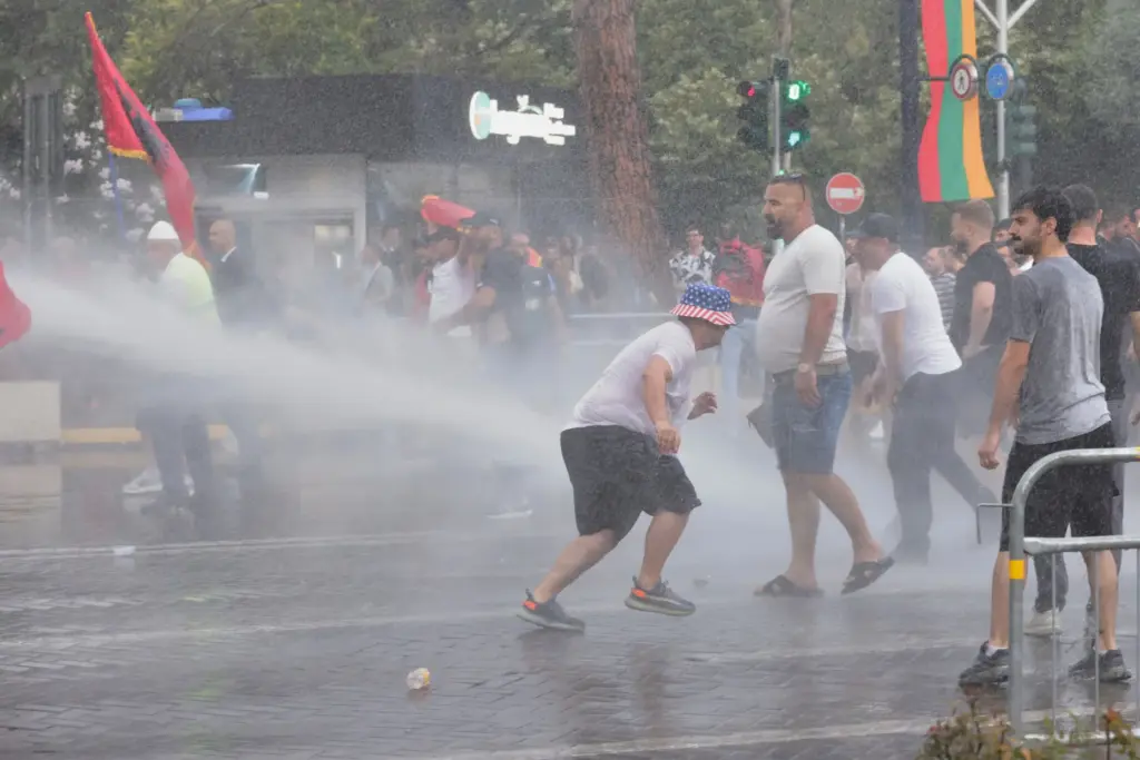 Police use a water cannon to disperse protesters during a...