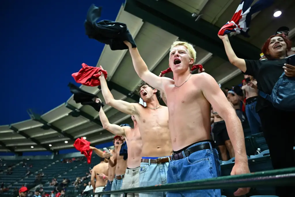 Shirtless fans cheer during the sixth inning of a game...