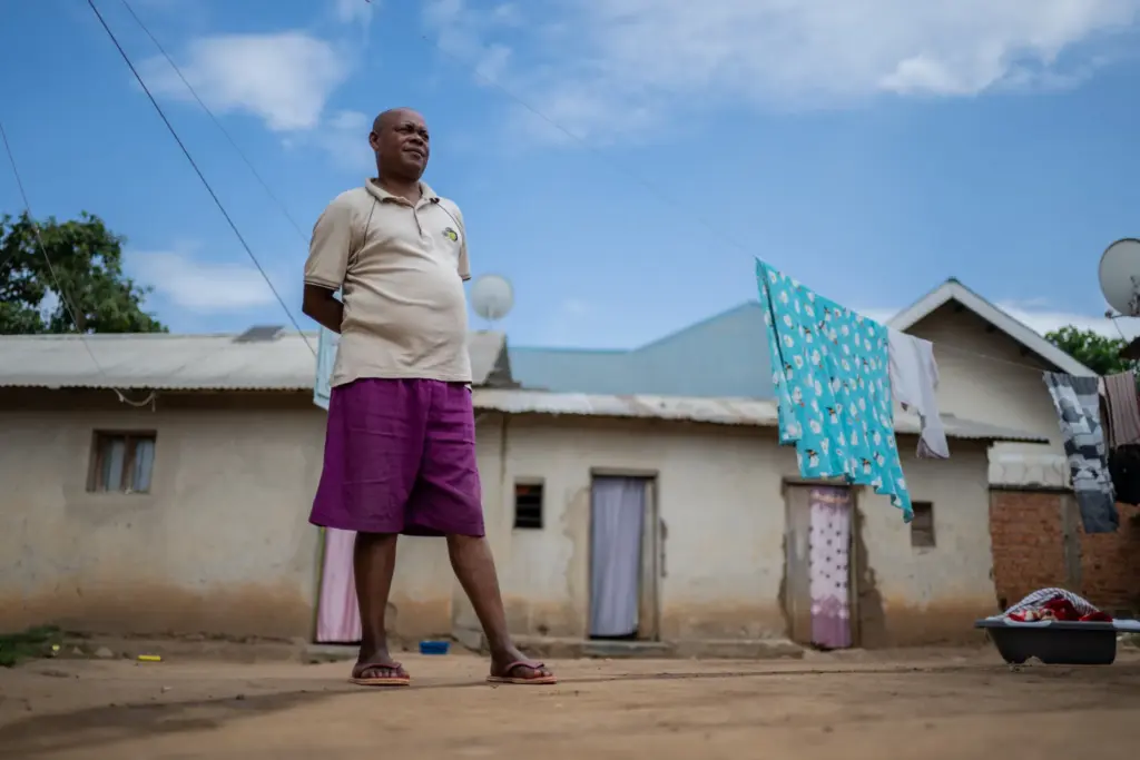 Samson Gerson, a resident skeptical about Ebola, stands outside his home.