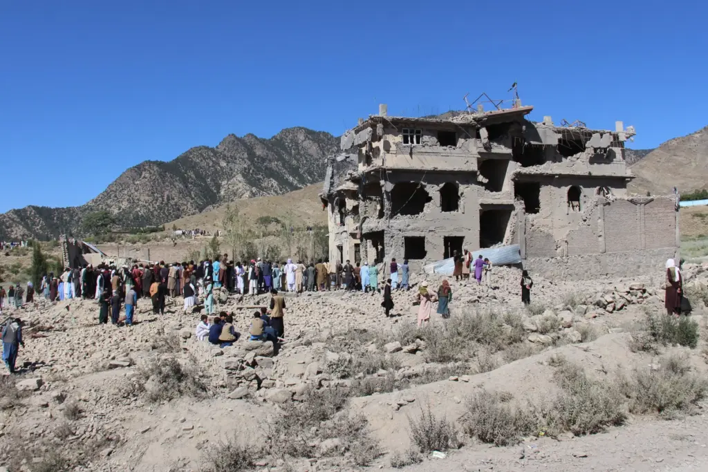 Residents walk through the rubble in Mandokhail, Afghanistan.