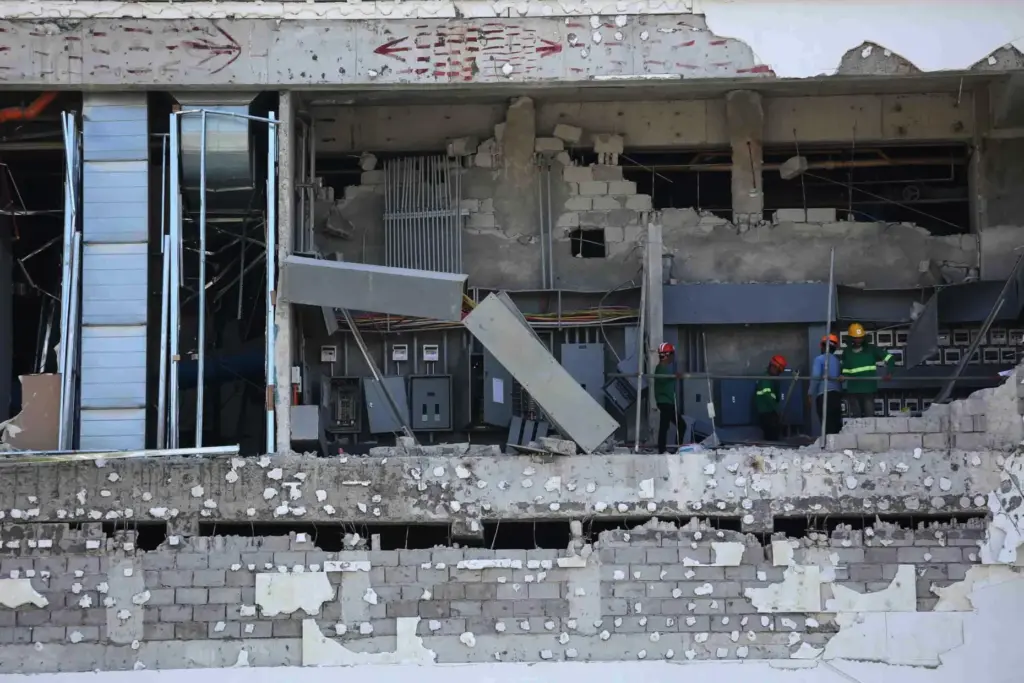Workers inspect a damaged mall in General Santos, southern Philippines,...
