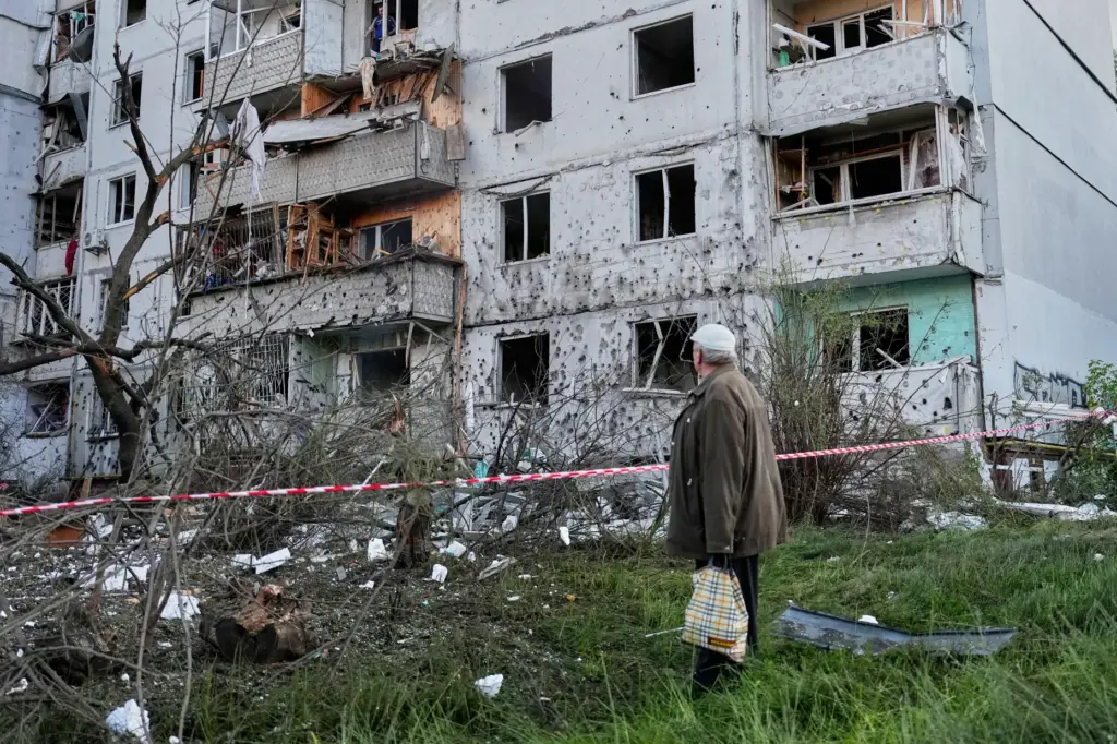 A resident looks at the site of a Russian missile strike that hit a residential building.