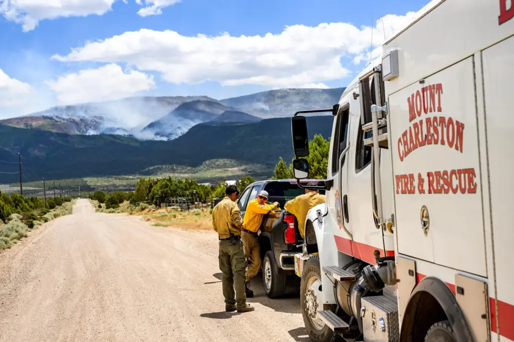 Firefighters gather as the Cottonwood Fire burns near Beaver, Utah,...