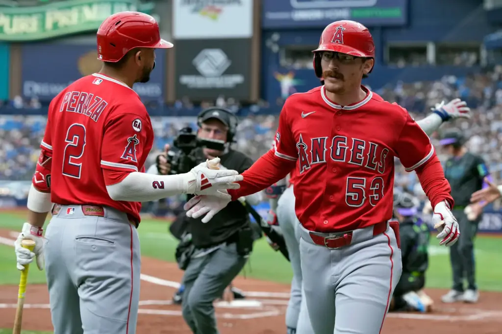 The Angels’ Wade Meckler, right, celebrates with teammate Oswald Peraza...