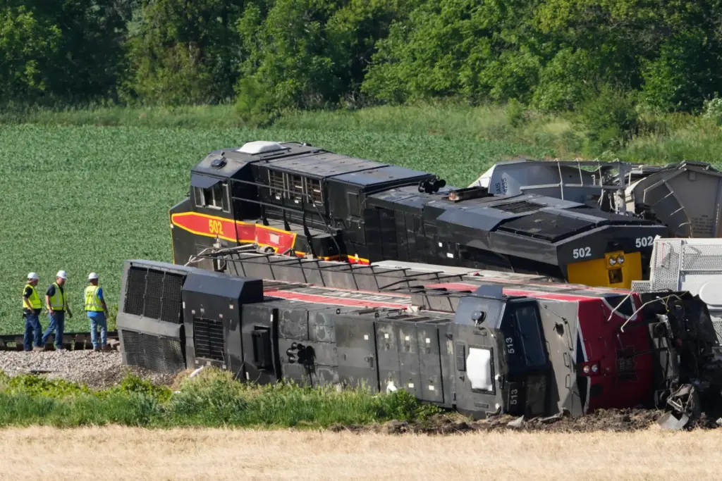 Workers respond after a train derailed on Wednesday, June 3,...