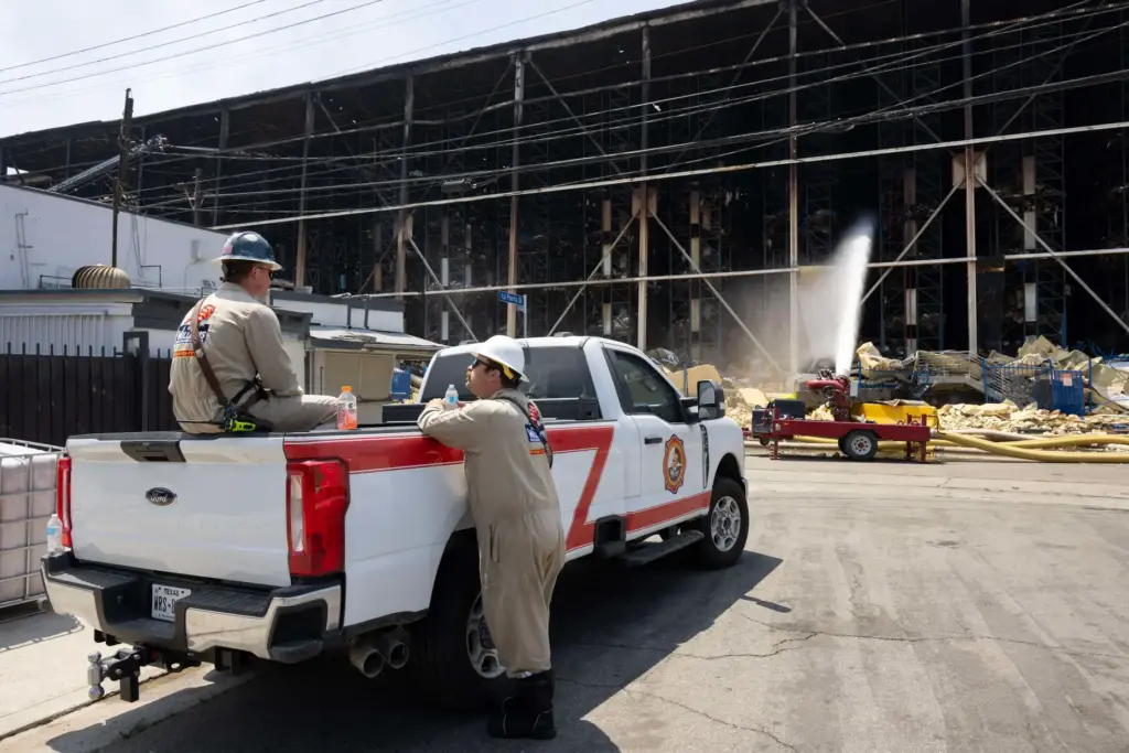 Firefighters and emergency crews continue to extinguish a fire at...