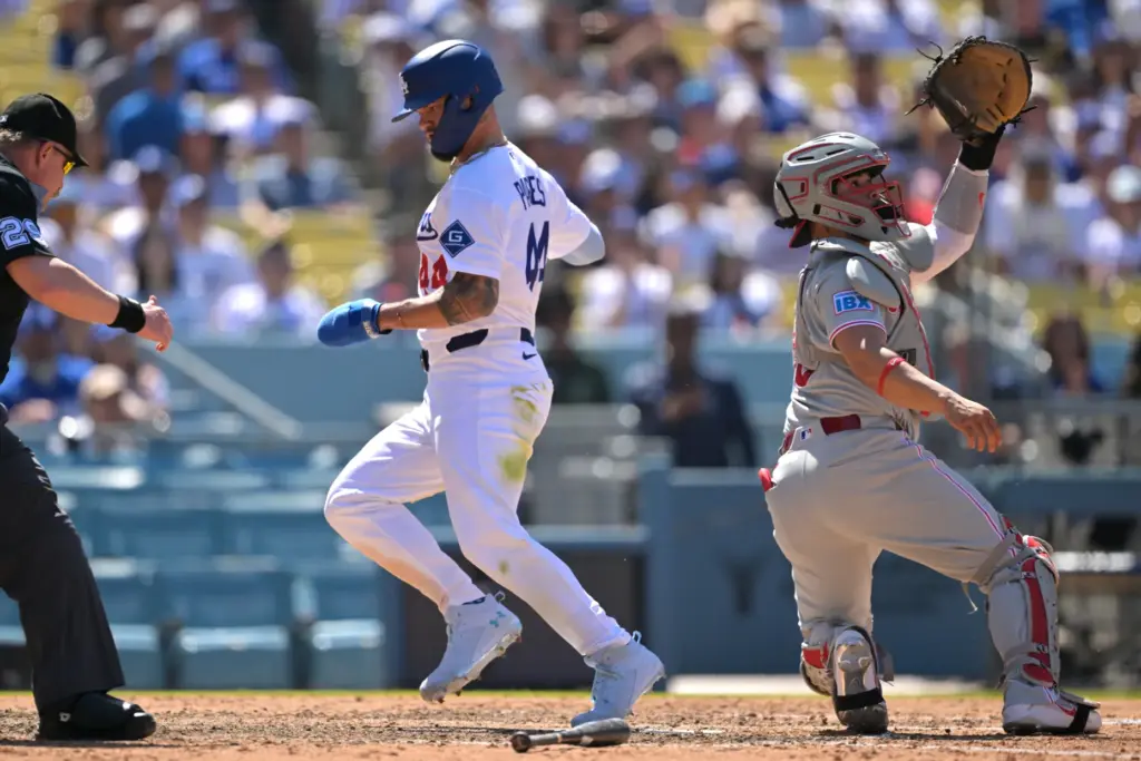 Dodgers’ Andy Pages, center, beats the throw to score a...