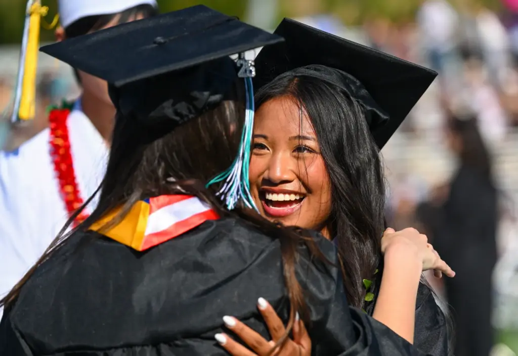 Graduate Kainani Libunao greets classmate Maddison Chappel after getting their...